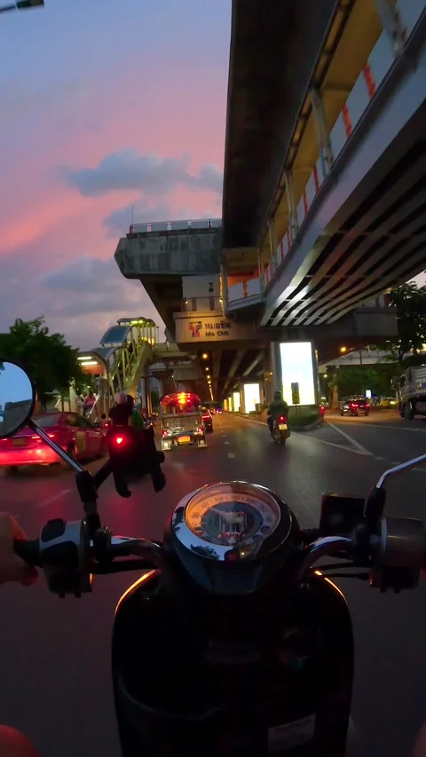 Evening hyperlapse of motorcycle riding on road next to BTS Skytrain in Bangkok Stock Footage 263701645