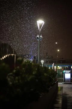 Evening. It's snowing in the light of a lantern Stock Photos