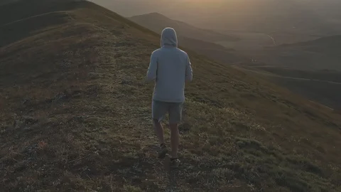 Evening jog on the hill against the backdrop of the mountains and the sunset Stock Footage 129607409