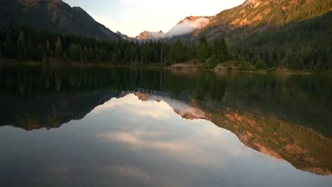Evening by lake with ripples mountain reflection, Pan shot bottom to top Stock Footage