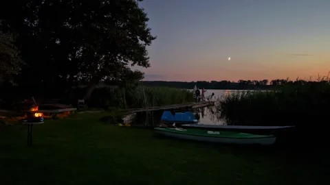 Evening Lakeside Walk with Campfire and Kayaks at Sunset Stock Footage 282275662