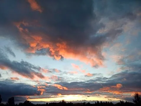 Evening landscape with dark clouds during sunset. Decline with bright clouds Stock Photos
