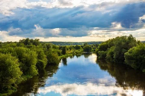Evening landscape with dramatic sky with clouds and river Stock Photos
