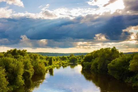 Evening landscape with dramatic sky with clouds and river Stock Photos