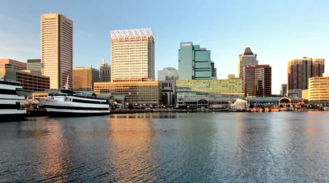 Evening light on the Baltimore skyline seen from the Inner Harbor in Baltimore Stock Footage 46314072