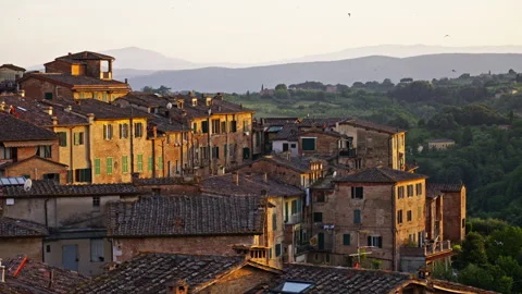 Evening Light on Rooftops with Hills and Lush Green Countryside Stock Footage 256238841