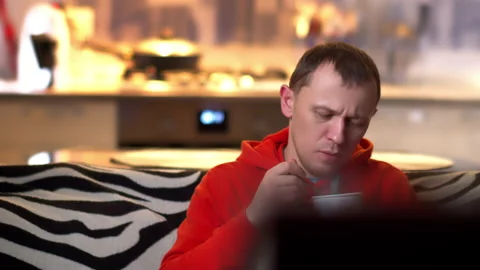 In the evening, a lonely man sits on the couch eating ice cream and watching TV. Stock Footage 137293818