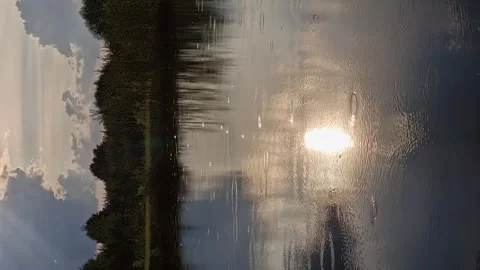 Evening low sun with clouds and water with their reflection and raindrops. Video stock 246636078