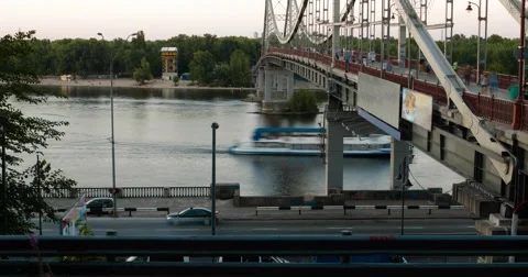 Evening motion of crowd, river and cars near a bridge across Dnieper river Видео 53476451