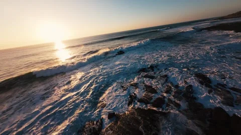 Evening ocean waves crash against rocky shore Stock Footage 339788869