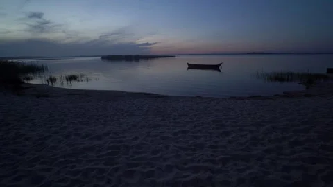 Evening or night panoramic sailing along the shore, beach, reeds, fishing wooden Stock Footage 240734593