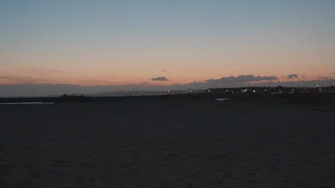 Evening panning view out to sea with woman taking selfies on the beach Stock Footage 106497688