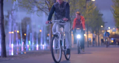 In the evening, in the park many cyclists ride on bike path Stock Footage 119566494
