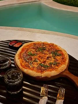 Evening Pizza by Poolside Glow. Stock Photos