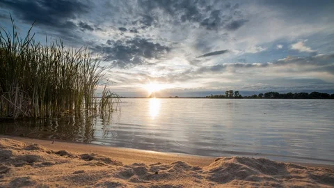 Evening at the pond with a sandy beach Stockbeeldmateriaal 112528623