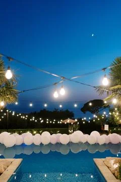Evening poolside celebration with string lights and balloons at Talici Hill Stock Photos