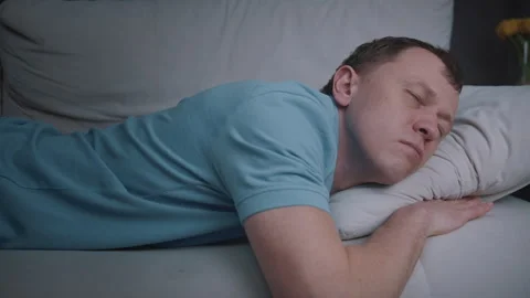 Evening Relaxation Man Trying to Fall Asleep on Couch Stock Footage 329952250