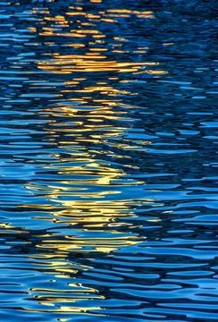 Evening river water texture with light reflection from a lantern. Stock Photos