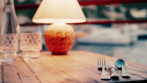 Evening romantic table setting outdoors by marina with warm lamp lighting a.. Stock Footage 339374052