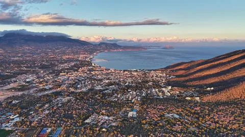 Evening scene captures vibrant sunset casting colors over coastal city and .. Stock Photos