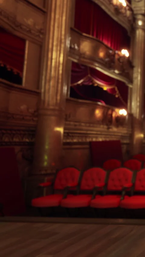 Evening scene inside a historic theater with empty red seats and stage lights Stock Footage 339508616