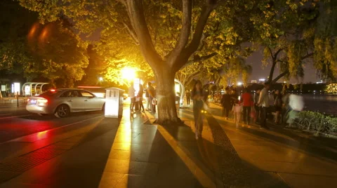 Evening scene of  streams of people and traffic on street by the lake. Stock Footage 46207760