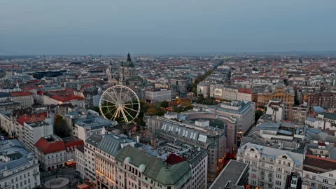 Evening settles over central Budapest as the Ferris wheel and St. Stephen’s Stock Footage 320233656