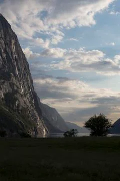 Evening shot of beautiful fjord valley, surrounded by mountains, cloudy blue Stock Photos
