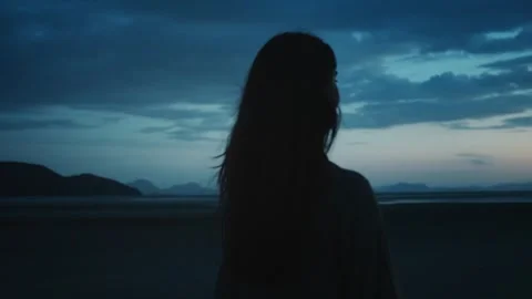 Evening silhouette of peaceful reflection. Young woman is enjoying beautiful Stock Footage 311293968