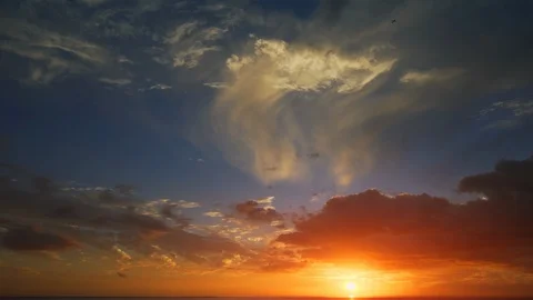 Evening sky with clouds and bright sun. Dark sunset over tropical sea Stock-Footage 129584894