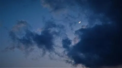 Evening sky with clouds and a young moon. Stock Photos
