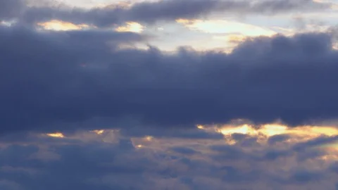 The evening sky, dark blue puffy fluffy clouds quickly rush past. Time lapse 4K Video stock 106016912