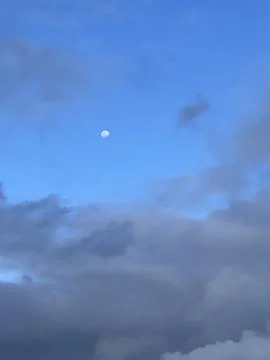 Evening Sky with Dark Clouds and Half Moon Stock Photos