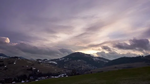 The evening sky is dramatic with clouds over hills and villages Stock Footage 277385438
