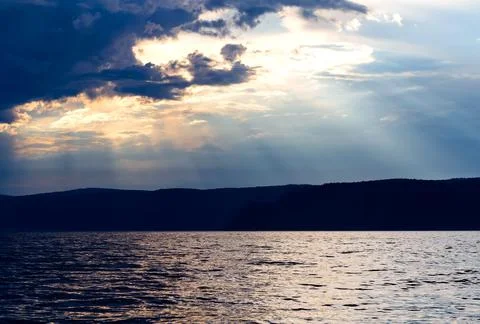 Evening sky with dramatic clouds over the sea. Dramatic sunset over the sea. Stock Photos