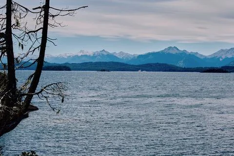 Evening sky with dramatic clouds over mountains, lake and trees Stock Photos