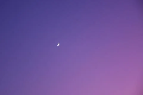 Evening sky with a gradient frompink to dark blue with little moon. Stock Photos