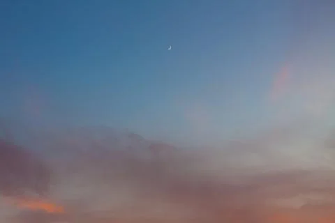 Evening sky with a moon and clouds at sunset Stock Photos