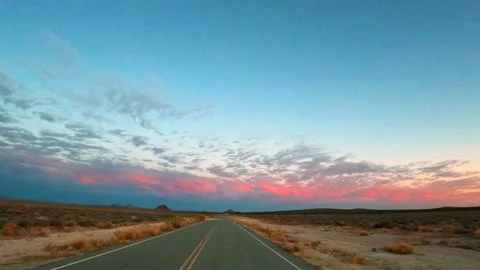 The evening sky is pink from the setting sun as you drive along this Stock Footage 142622405
