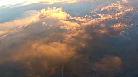 Evening sky is reflected in river. Beautiful clouds reflected in flow of water. Stock Footage 255805670