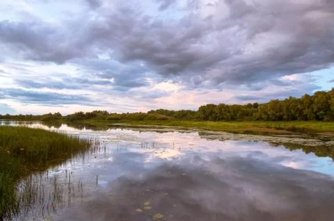 The evening sky is reflected in the river... Stock Photos