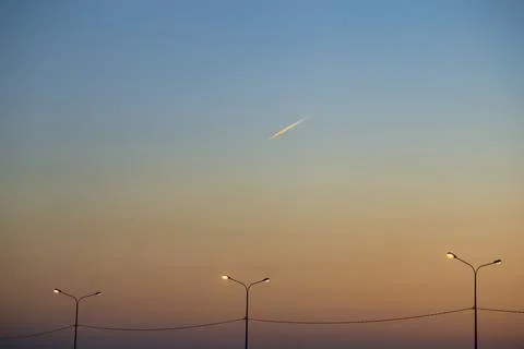 Evening sky at sunset with a flying plane. Travel, summer and relaxation concept Stock Photos