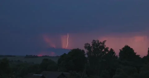 Evening sky thunderstorm lightning over field and village an impending storm Stock Footage 132953014