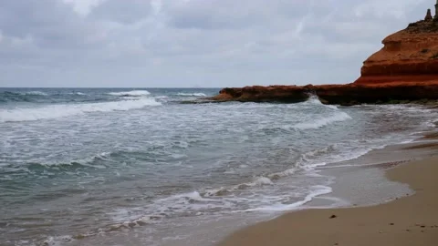 In the evening, small waves splash onto the beach in slow motion. Stock Footage 138208859