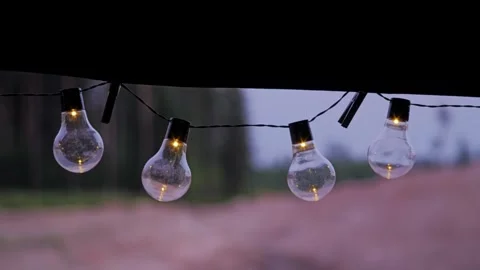 Evening string lights glow from inside rooftop tent in cozy slow-motion shot Stock Footage 315285964
