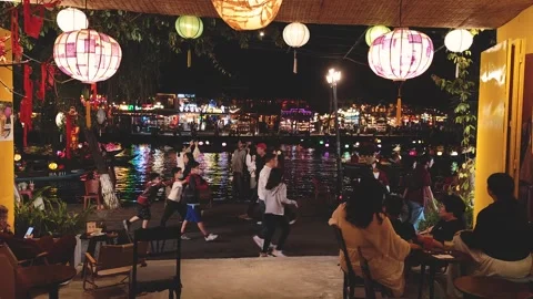 Evening stroll along the river in a vibrant lantern-lit town Stock Footage 310424523
