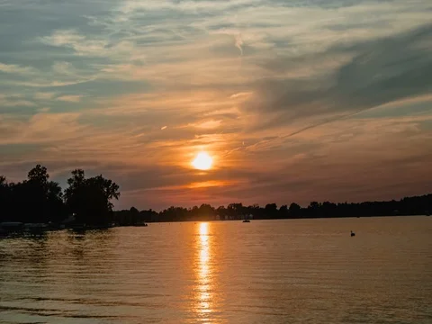 Evening sun descending behind the clouds - time lapse Video stock 77826619