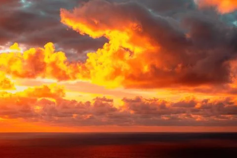 Evening sun hiding behind clouds Stock Photos