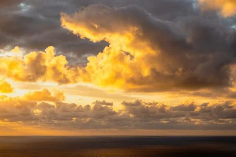 Evening sun hiding behind clouds Stock Photos