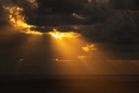 Evening sun hiding behind clouds Stock Photos